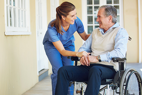 Senior man in wheelchair with caregiver