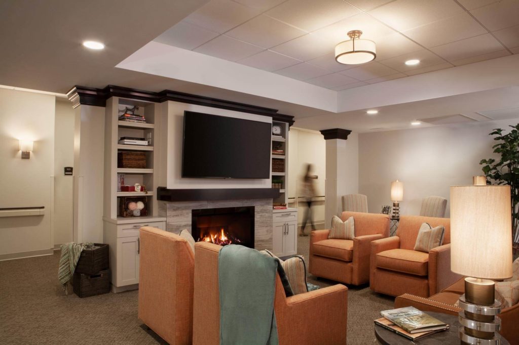 Lounge area with chairs, fireplace, and tV