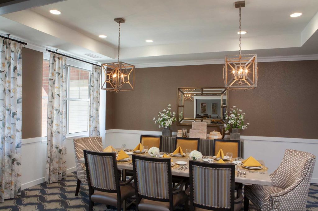 Dining room table surrounded by chairs and decorate lighting