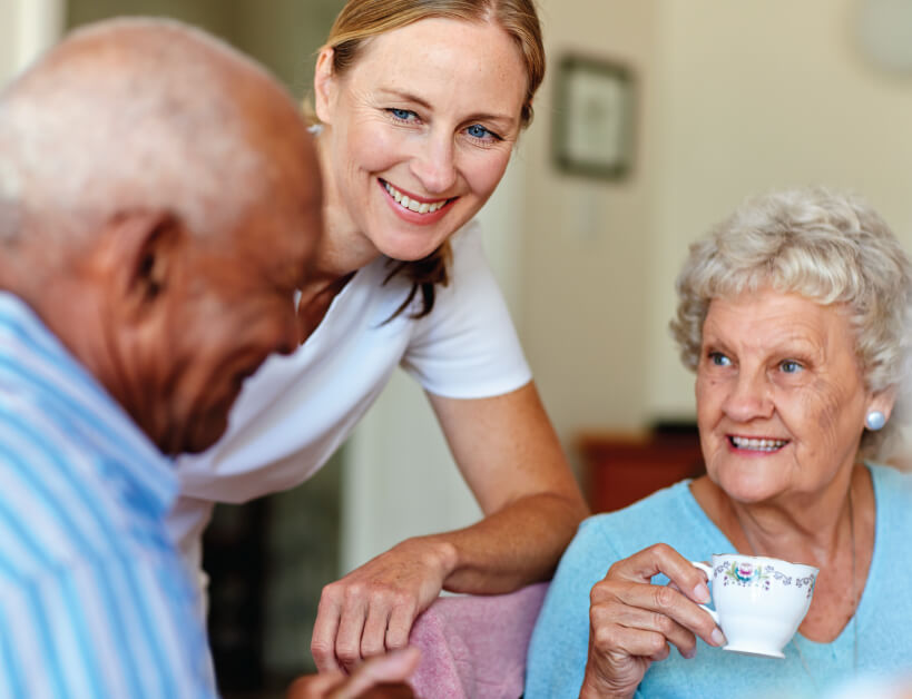 Employee serving tea to senior couple