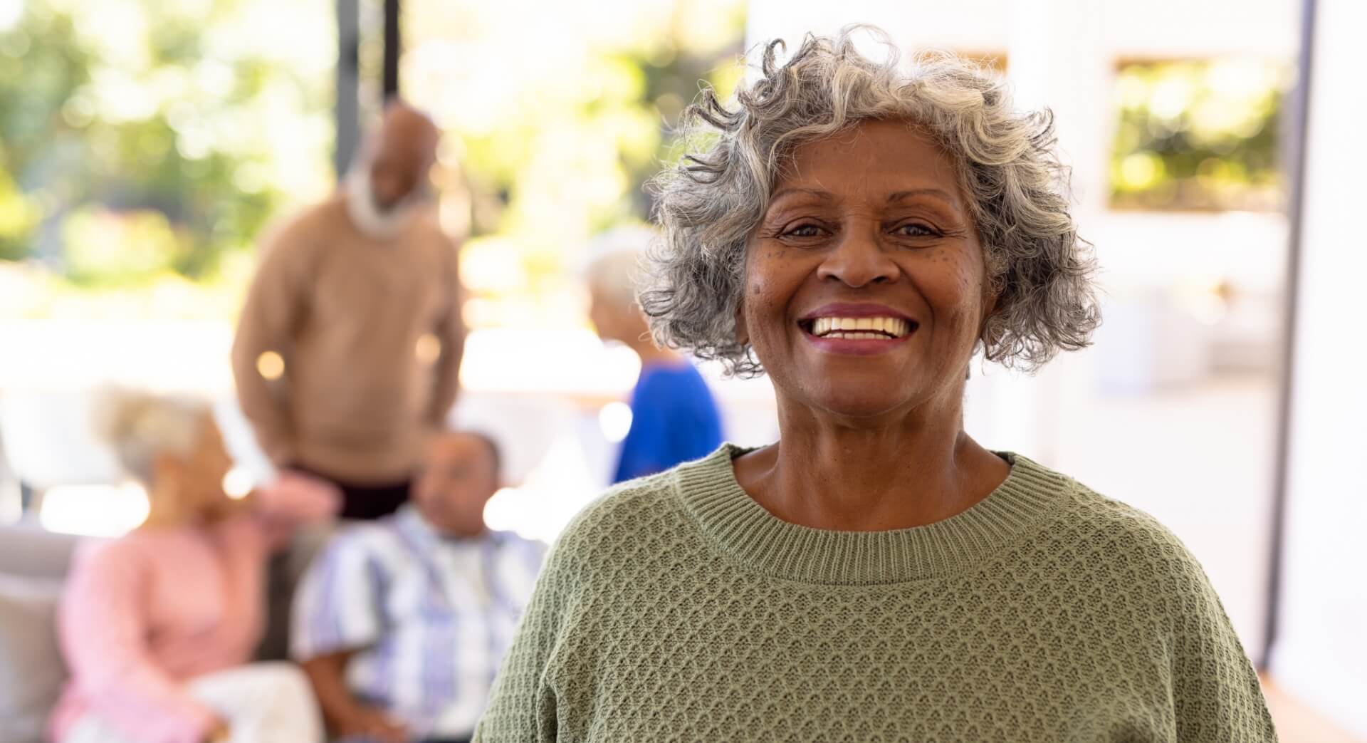 Happy senior woman smiles with group of friends in the background